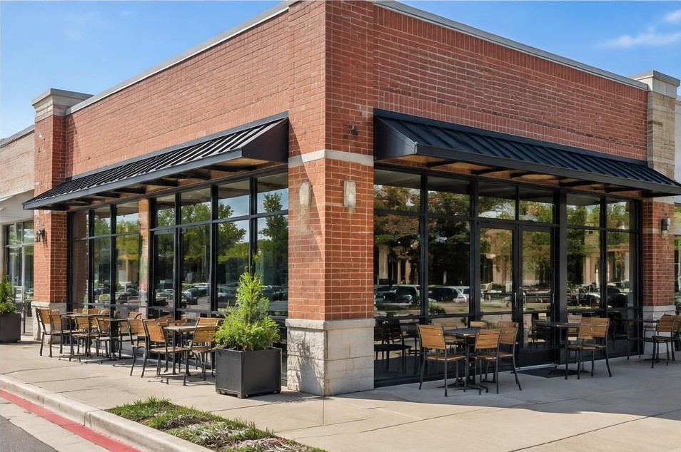 Corner café with black-framed glass frontage and outdoor tables