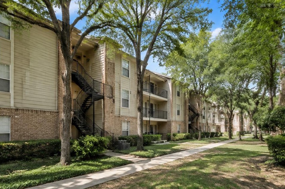 Illustrative Class B apartments with exterior stairs and mature trees