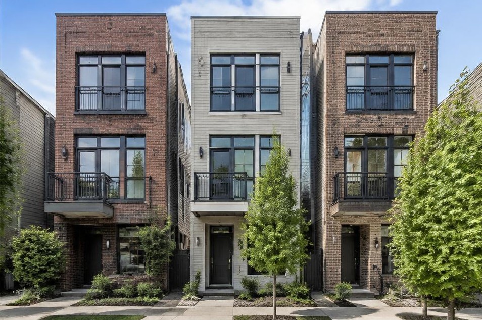 Three attached brick and siding townhouses with tall front windows